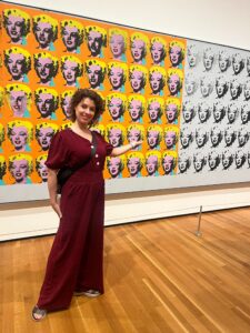 Un profesor de ODLS de pie delante de una obra de Andy Warhol.
